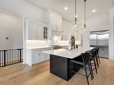 Bright White Kitchen with Black Island in Prosper, TX by SHADELE Design & Remodeling
